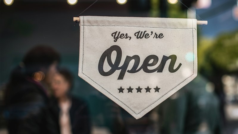 An “Open” sign hanging in a shop window