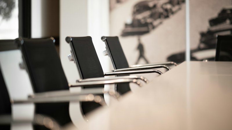 Black office chairs lined up at a conference table